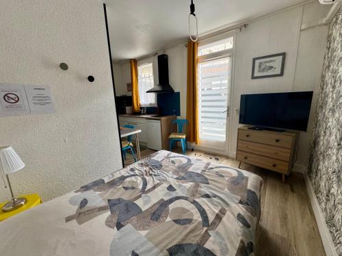 une chambre avec un lit et une télévision à écran plat dans l'établissement L'escapade Angoumoisine, studio idéalement situé, à Angoulême