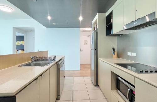 a kitchen with a sink and a counter top at '10-A' Coral Sea Apartment - Pool & Ocean Views in Cairns