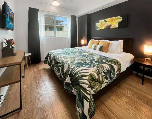 a hotel room with a bed and two tables at '10-A' Coral Sea Apartment - Pool & Ocean Views in Cairns