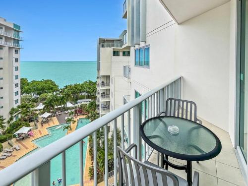 a balcony with a table and a view of the ocean at '10-A' Coral Sea Apartment - Pool & Ocean Views in Cairns