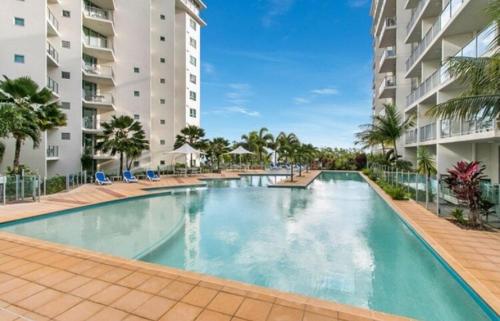 a large swimming pool in front of a building at '10-A' Coral Sea Apartment - Pool & Ocean Views in Cairns