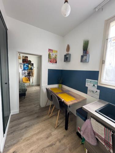 une chambre avec une table et une cuisine aux murs bleus dans l'établissement La bulle d'Angouleme, à Angoulême