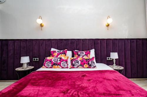 a bedroom with a large bed with pink sheets and pillows at Domaine Terra Cotta - Villa de luxe avec piscine sans vis-à-vis in Souk el Had