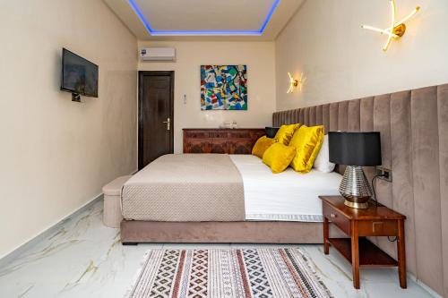 a bedroom with a bed with yellow pillows and a table at Domaine Terra Cotta - Villa de luxe avec piscine sans vis-à-vis in Souk el Had