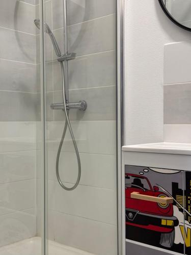 une douche avec une porte vitrée avec un autocollant de voiture de course dans l'établissement La bulle d'Angouleme, à Angoulême