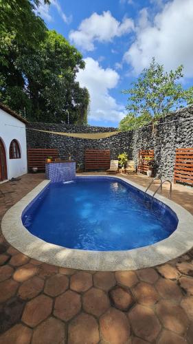a large swimming pool in a patio with a stone wall at Hotel Amigo Nicaragua in Nindirí