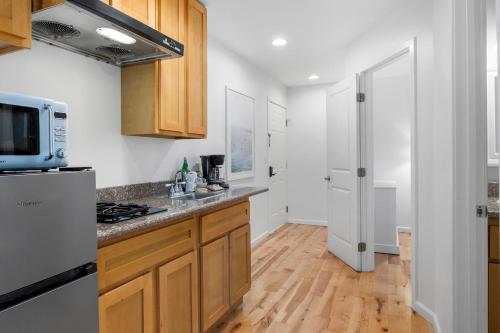 a kitchen with wooden cabinets and a microwave at Swell House Santa Cruz in Santa Cruz