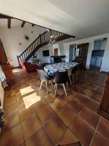 un salon avec une table et des chaises et un escalier dans l'établissement La Dolce Vita, à Marseillan