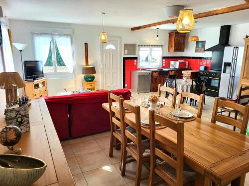 a kitchen and living room with a wooden table and chairs at Chez ptit Claude, bord de mer in Créances