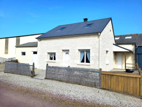 a white brick house with a black roof at Chez ptit Claude, bord de mer in Créances