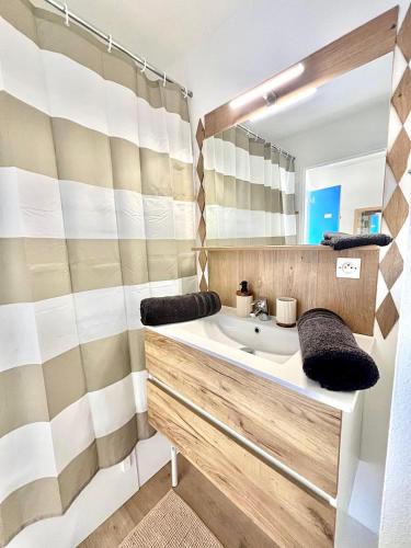 une salle de bain avec un lavabo et un miroir dans l'établissement Le Petit Vaucluse Parking Wi-Fi, à Avignon