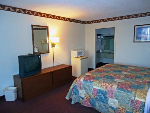 a hotel room with a bed and a television at Motel 6-Troy, OH in Troy