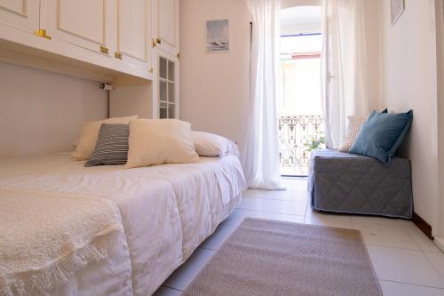 a bedroom with a bed and a chair and a window at 245c - Casa Johanna, Centro Storico, 140metri dalla Baia del Silenzio PATRIMONIO UNESCO spiaggia e mare in Sestri Levante