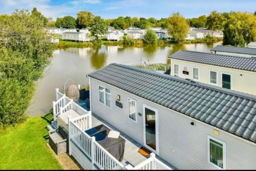 una vista aérea de una casa sobre el agua en Exquisite Lake lodge in Hoburne Holiday Resort - Valentino Rose Lodge, en South Cerney