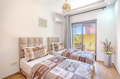 une chambre avec deux lits et un balcon dans l'établissement Appartement élégant et cosy, à Marrakech