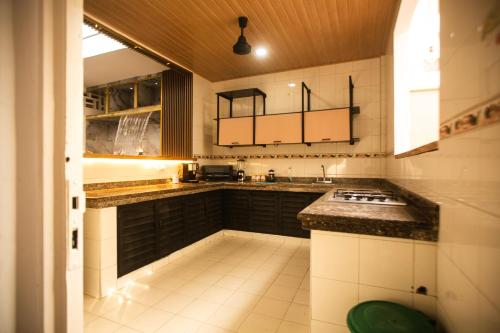 Il comprend une cuisine avec des placards noirs et du carrelage blanc. dans l'établissement Casa Santa Cruz & Social Coffee, à Carthagène des Indes