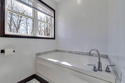 a white bathroom with a sink and a window at Home in Bushkill Saw Creek Poconos area in Saw Creek