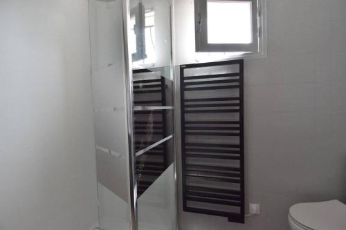 ein Badezimmer mit Toilette und Fenster in der Unterkunft Maison à 300 m de la plage et centre avec piscine in La Couarde-sur-Mer