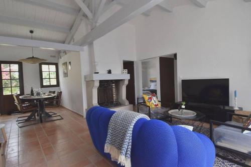un salon avec un canapé bleu et une cheminée dans l'établissement Maison à 300 m de la plage et centre avec piscine, à La Couarde-sur-Mer