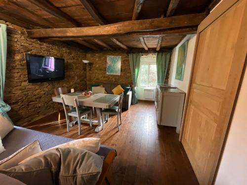 une salle à manger avec une table et une télévision dans l'établissement La charmante **** Maison Cap Corse, Tomino, à Mandolacce