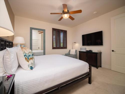 a bedroom with a white bed with a ceiling fan at Totally Revamped Pacific Paradise J505 At Wbv! -Top Floor Ocean Views! in Wailea