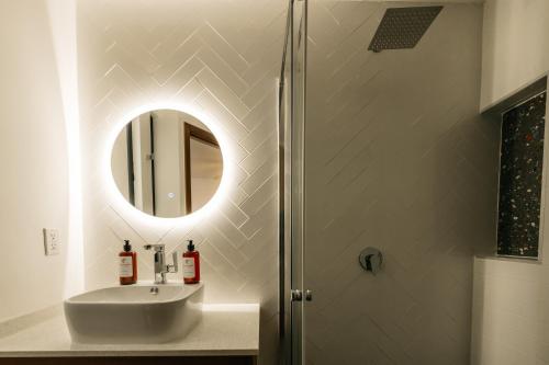 a bathroom with a sink and a shower with a mirror at Casa Castillo Condesa in Mexico City