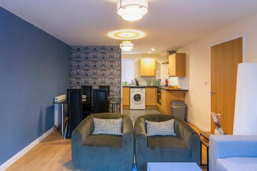 a living room with two couches and a kitchen at The Vogue Stay, 3 Bedrooms, 2 bathrooms, Ideal for JR & Oxford Hospitals, FREE CarPark, Conveniently located for Ring Road access, 2 miles from Oxford City Centre easy car & bus route in Oxford