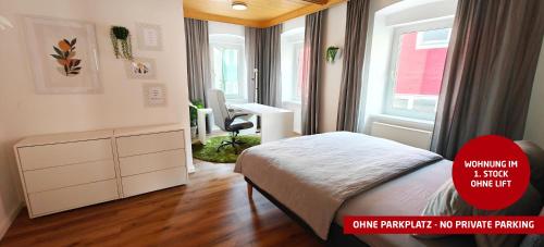 a bedroom with a bed and a desk and a window at Ferienwohnungen Meier in Ebensee