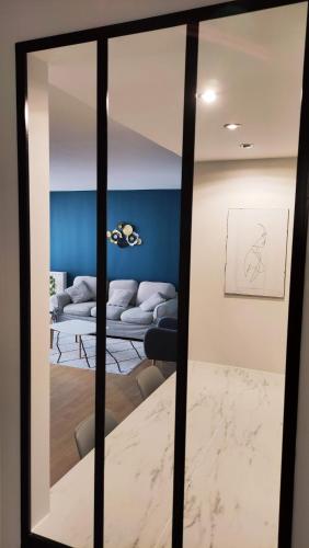un miroir reflétant un salon avec un canapé dans l'établissement Appartement calme et confortable, à Limoges