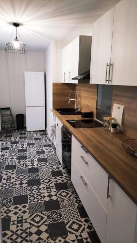 Il comprend une cuisine dotée de carrelage noir et blanc. dans l'établissement Appartement calme et confortable, à Limoges