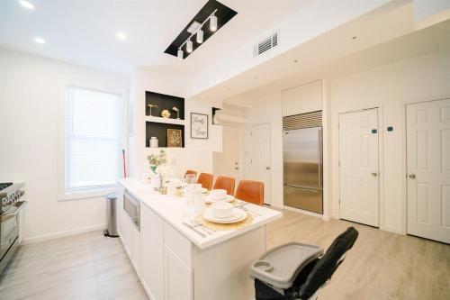 a kitchen with white cabinets and a table and chairs at Modern 5BR DC Home Free Parking Steps from Metro Family-Friendly in Washington, D.C.