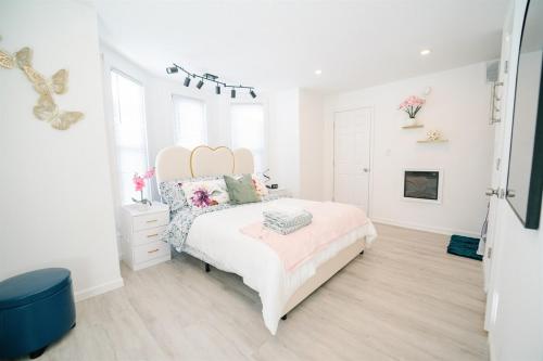 a white bedroom with a bed and a fireplace at Modern 5BR DC Home Free Parking Steps from Metro Family-Friendly in Washington, D.C.