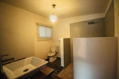 a bathroom with a white sink and a toilet at Casa Tobala in Acapulco
