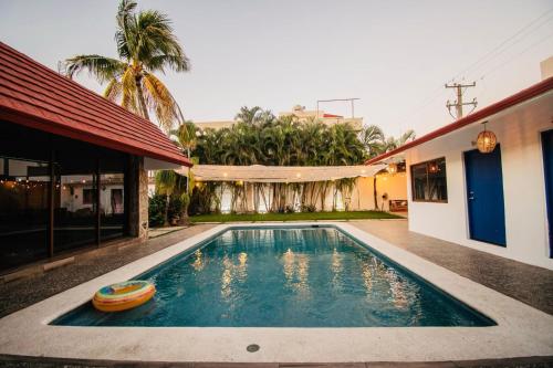 a swimming pool in front of a house at Casa Tobala in Acapulco
