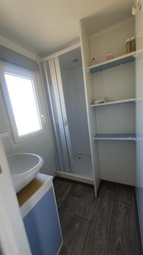 une salle de bain avec un lavabo blanc et une fenêtre dans l'établissement Séjour au cœur du Minervois, à Azille