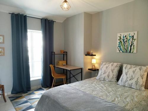 a bedroom with a bed and a table and a window at Charmant Pied à Terre a Blois pour 1 a 4 voyageurs in Blois