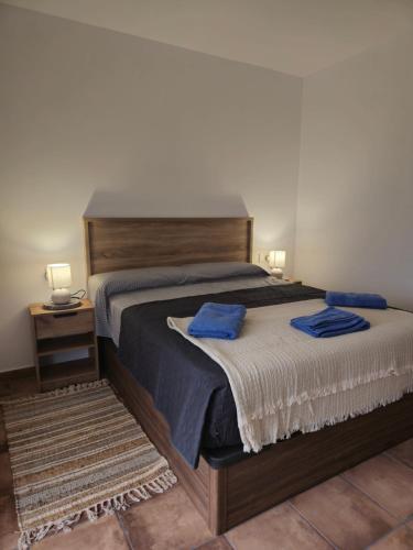 a bedroom with a large bed with blue towels on it at Casa Rural El Bressol in Barraca de Aguas Vivas