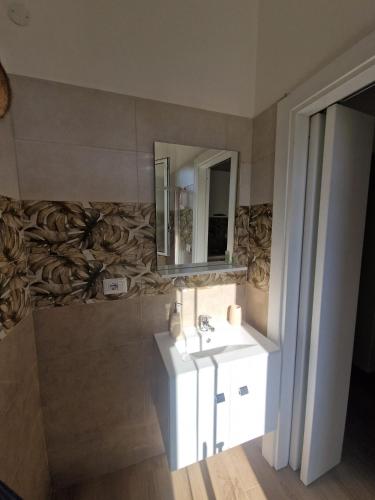 a bathroom with a sink and a mirror at Casa vacanze Grimaldi Paestum in Paestum