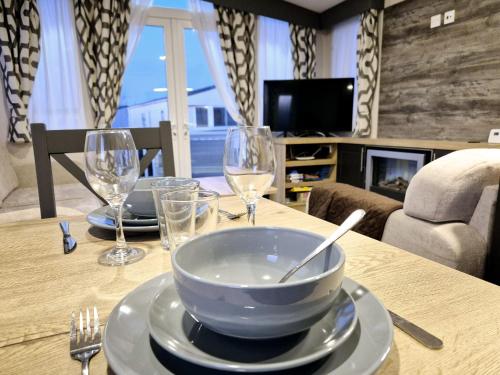 a table with a bowl and wine glasses on it at Birchington Vale - Luxury 3 bed, Pet friendly & Family Friend in Margate