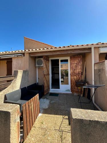 une porte d'entrée d'une maison avec une terrasse dans l'établissement La maison du bonheur, à Leucate-Plage