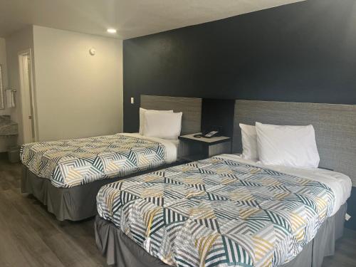 a hotel room with two beds and a black wall at Motel 6 Vicksburg, MS in Vicksburg