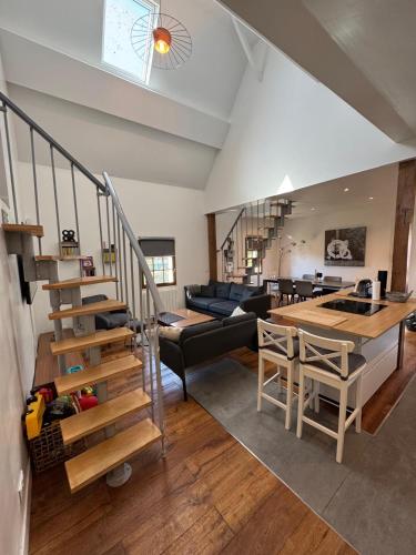 un salon avec un escalier et une salle à manger dans l'établissement La tanière de Bonneville, à Bonneville-sur-Touques