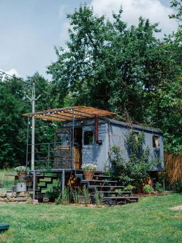 an old caravan with a roof and stairs in a yard at Ubytování Maringote in Doubravice