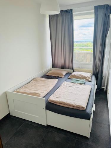 two beds in a room with a window at Appart meublé 92m2 + 2 terrasses in Brussels
