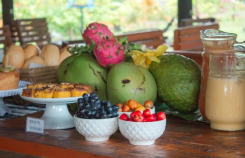 Una mesa cubierta con cuencos de frutas y verduras en Pousada Vila do Sol Corumbau, en Corumbau