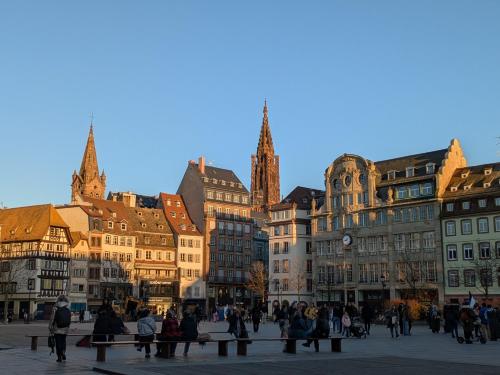 un groupe de personnes se promenant dans une ville avec des bâtiments dans l'établissement La Nuée Bleue, à Strasbourg
