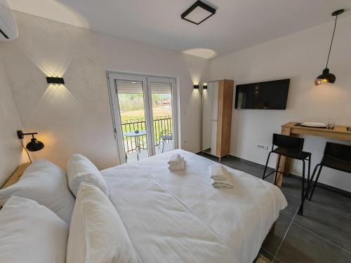 a large white bed in a room with a balcony at Apartman Holiday 2 in Veliko Gradište