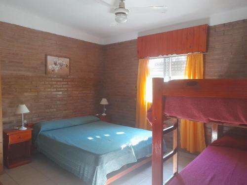 a bedroom with two bunk beds and a window at Cabañassoleado Villa Cura Brochero in Villa Cura Brochero
