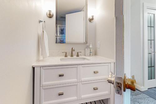 a white bathroom with a sink and a mirror at Beach Bahr Den in Santa Rosa Beach