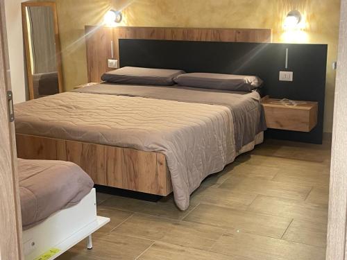 a bedroom with a large bed with a wooden headboard at airport room -1 in Azzano San Paolo